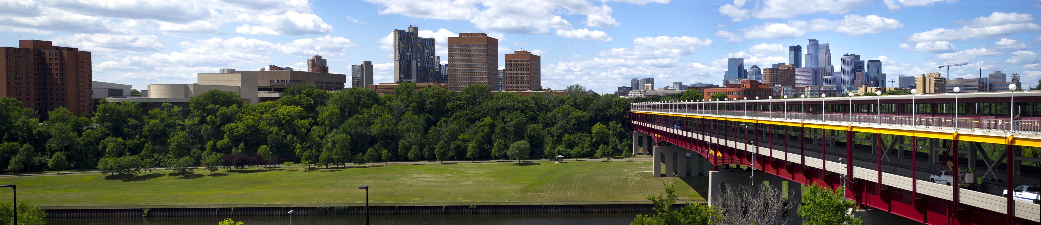 panorama of the Minneapolis skyline, the Washington Avenue Bridge, and the UMN West Bank